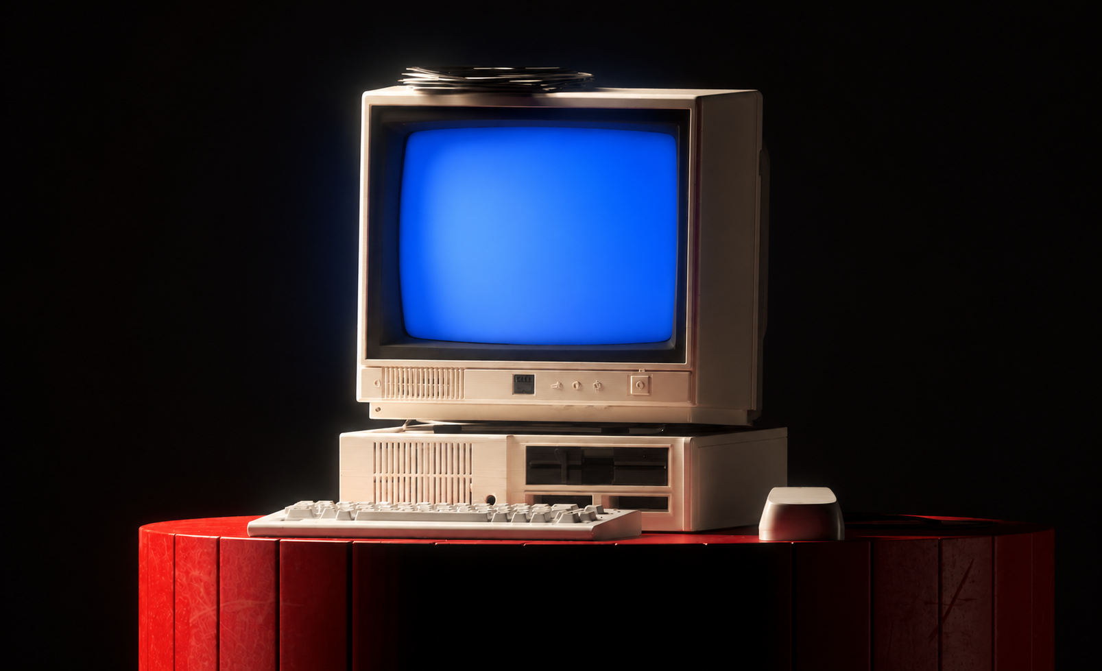 A vintage CRT computer glowing on a red desk